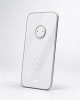 A transparent glass smartphone case with a silver metallic edge, featuring a circular camera cutout and a subtle lightning-bolt logo near the bottom, shown on a light gray background.